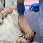 Un enfermero vacuna de la dosis Moderna a una anciana durante el inicio de la administración de la cuarta dosis de la vacuna frente al COVID-19