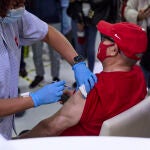 Una sanitaria vacuna a un hombre en una residencia de mayores de Madrid