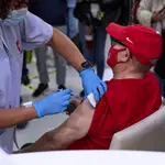 Una sanitaria vacuna a un hombre en una residencia de mayores de Madrid