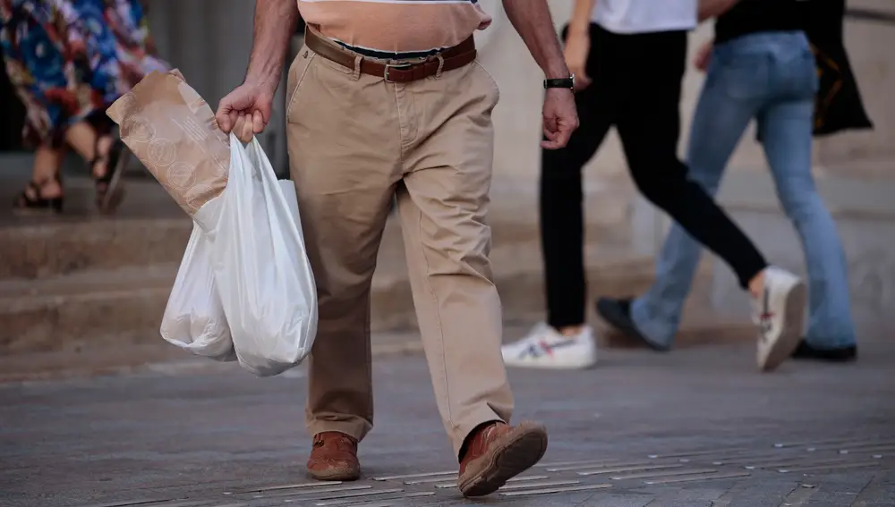 Imagen de un hombre llevando la compra