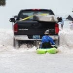 Un camión arrastra a un hombre en un kayak después de una inundación tras el paso del huracán Ian, en Key West, Florida