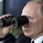 Vladimir Putin mira a través de unos anteojos el desarrollo de una maniobras militares del ejército ruso