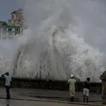 Varias personas se detienen en el Malecón de La Habana mientras enormes olas chocan contra el paseo marítimo tras el paso del huracán Ian