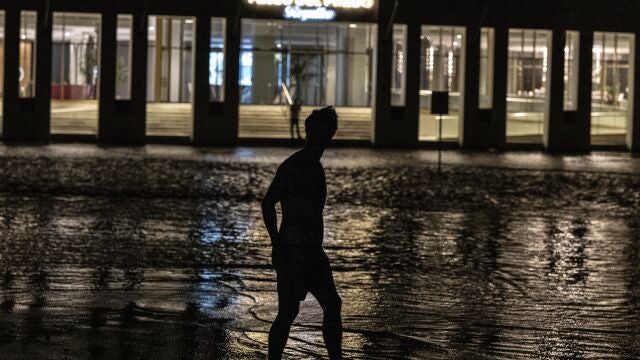 Un hombre camina por una calle inundada frente a un hotel alimentado por un generador de petróleo durante un apagón en La Habana, Cuba, el miércoles 28 de septiembre de 2022. (AP Photo/Ramon Espinosa)
