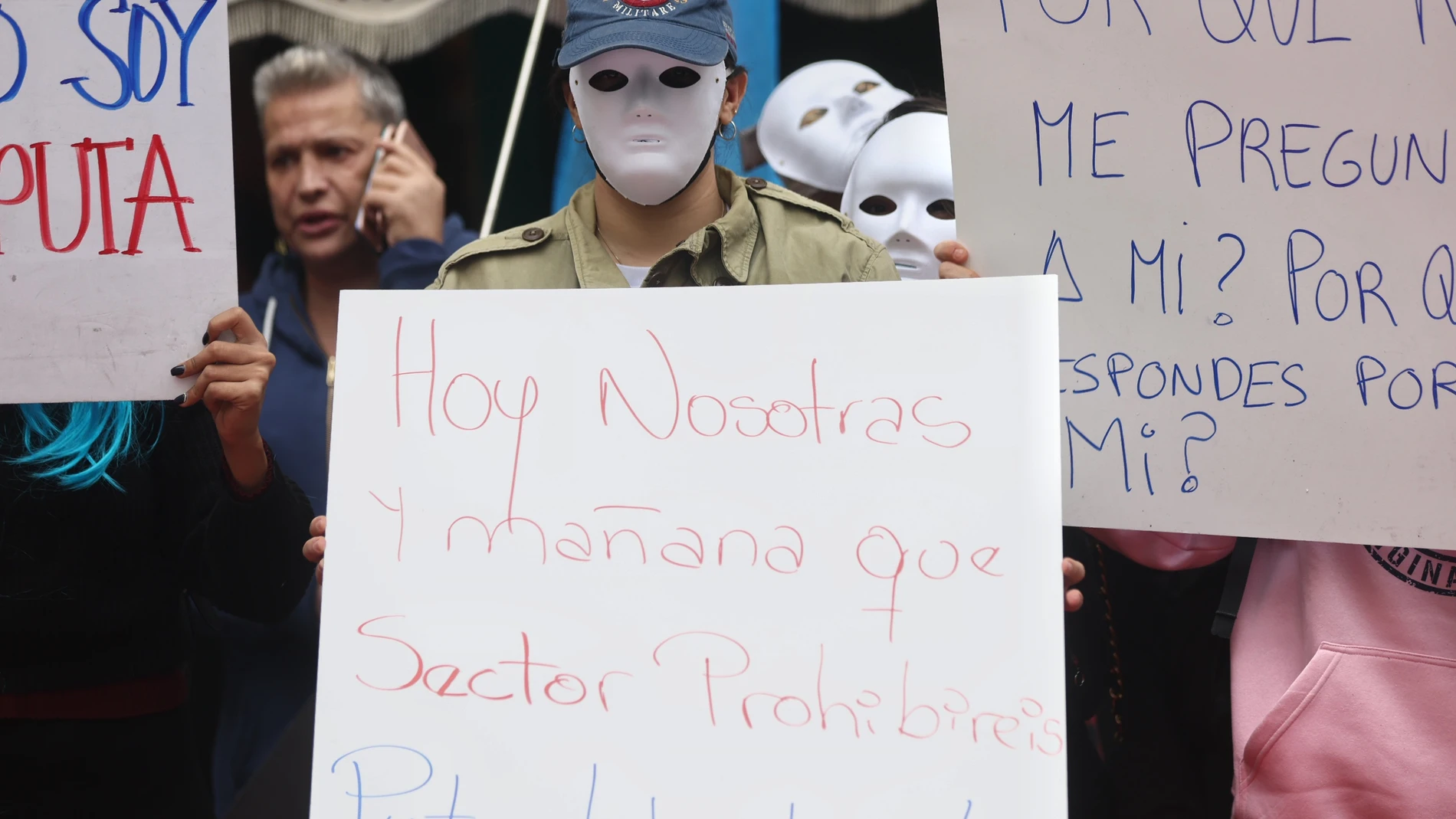 Varias prostitutas y miembros de la plataforma #StopAbolición exhiben carteles de protesta en contra de la ley del Gobierno para acabar con el proxenetismo, durante una concentración frente al Congreso de los Diputados