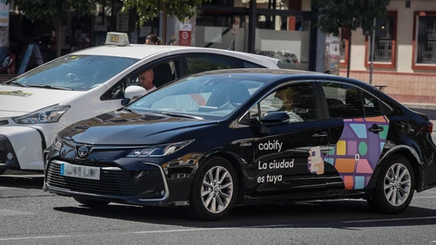 Un taxi frente a un VTC en Sevilla. EFE /Jose Manuel Vidal