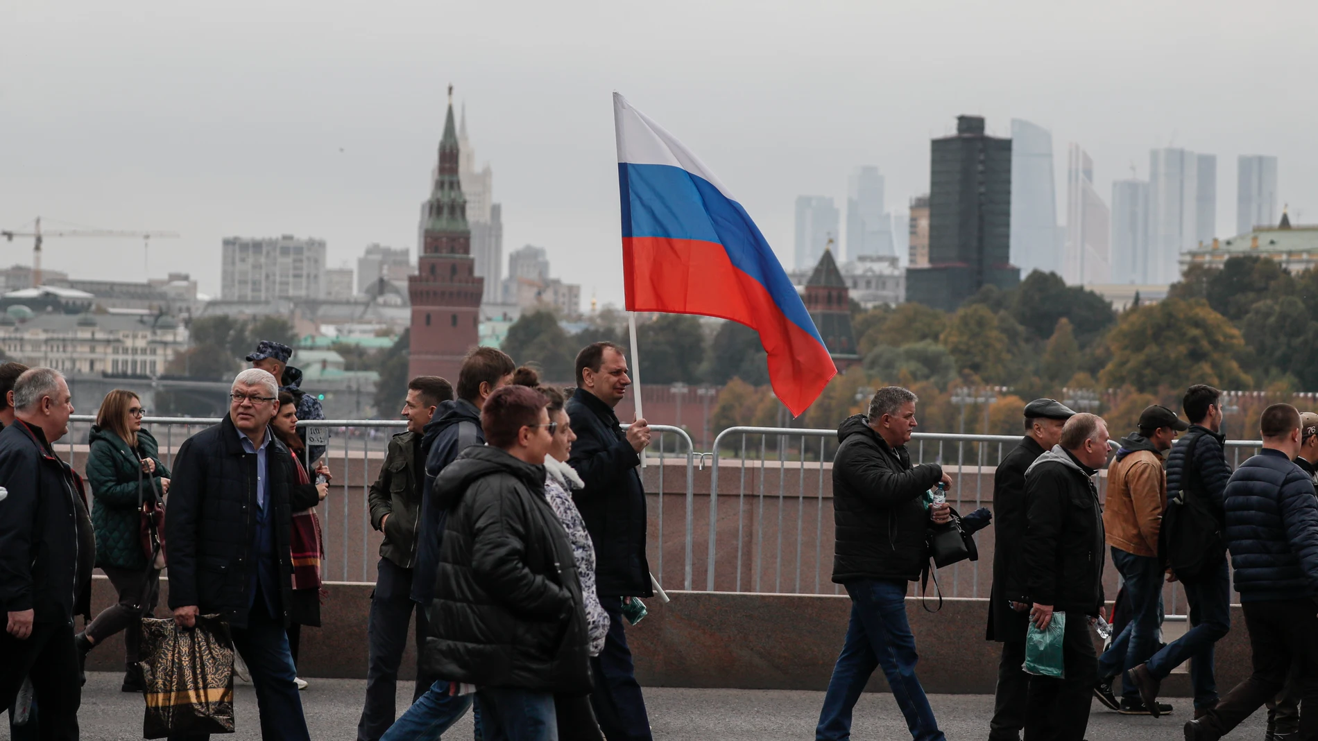 Rusos con banderas rusas se preparan para celebrar la anexión anunciada por Putin de los territorios ucranianos
