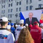 Un grupo de personas presencia el último discurso del presidente ruso Vladimir Putin