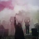 Manifestantes sostienen fuegos artificiales con los colores nacionales de Irán durante un mitin de "Solidaridad con el levantamiento civil en Irán" en la plaza Bebel Platz de Berlín