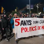 Miembros del CDR Girona portan una pancarta que dice &quot;cinco años de una gran estafa. Políticos de mierda&quot; durante una manifestación con motivo del quinto aniversario del referéndum del 1-O.