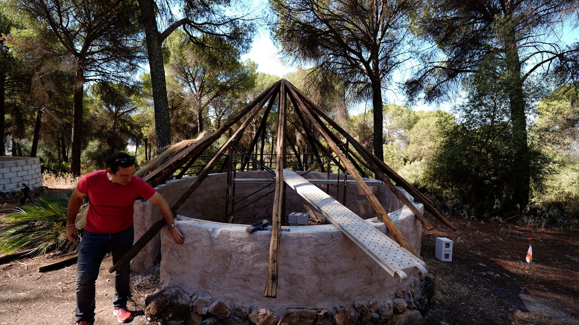 Alejandro Galán, director y arqueólogo del poblado, junto a una de las construcciones en el yacimiento arqueológico en la localidad cordobesa de Posadas. EFE/ Rafa Alcaide