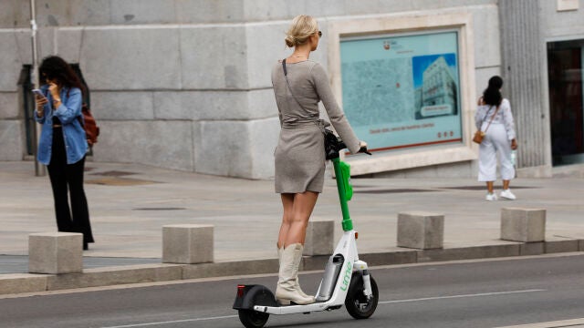 Imagen de una chica sobre un patinete eléctrico de alquiler.