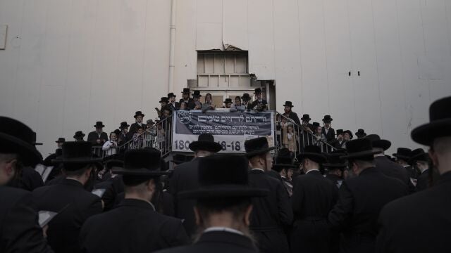 Judíos ultraortodoxos se reúnen alrededor de una piscina de plástico con agua y peces mientras participan en una ceremonia de Tashlich en la ciudad israelí ultraortodoxa de Bnei Brak, cerca de Tel Aviv, el lunes 3 de octubre de 2022. (AP Photo/Oded Balilty)