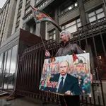 Un hombre sostiene una pancarta en la que se lee &quot;Estamos con él. ¿Y tú? Por la soberanía de Rusia&#39;, en los alrededores del edificio de la Duma Estatal de Rusia en Moscú