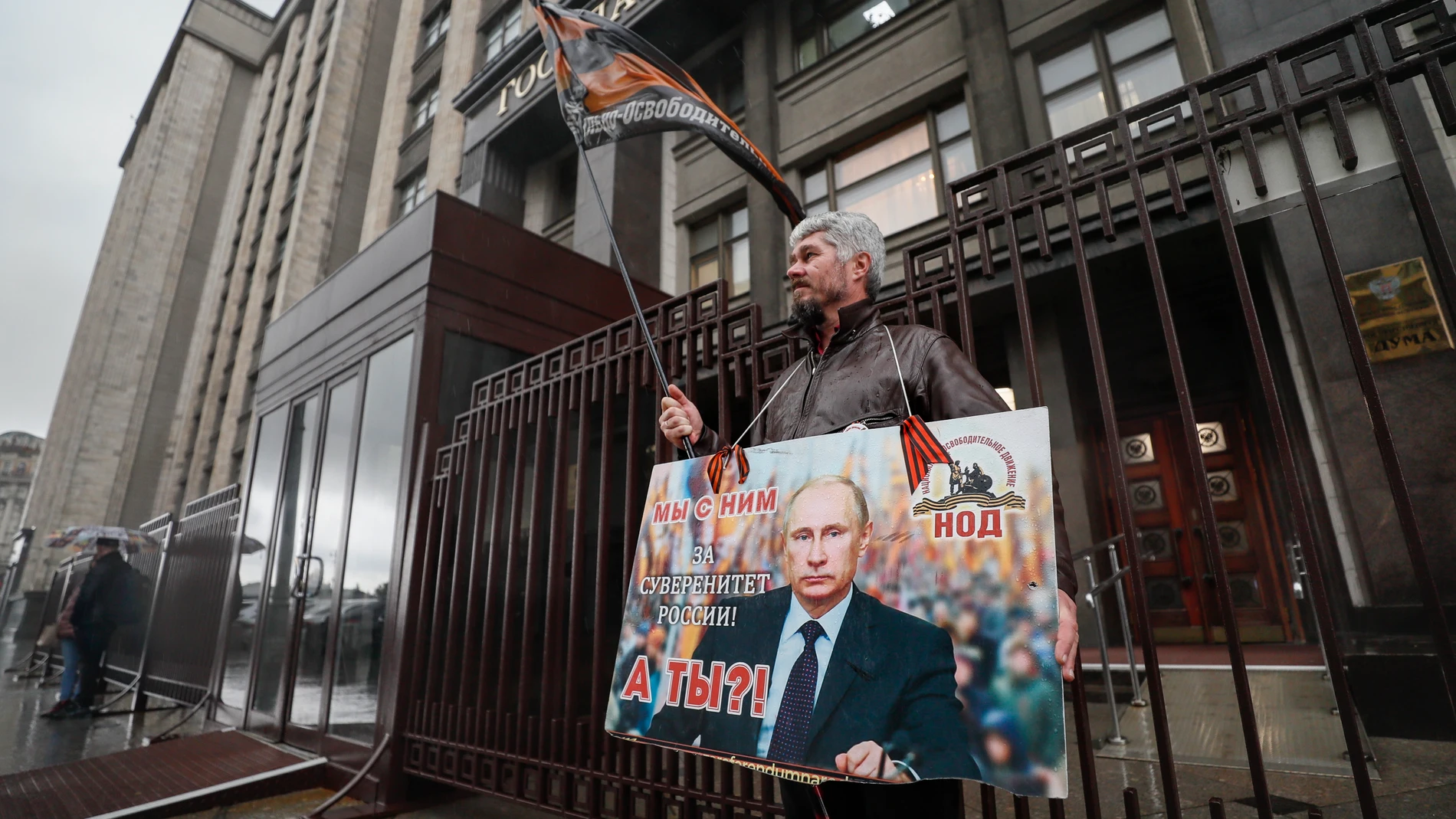 Un hombre sostiene una pancarta en la que se lee "Estamos con él. ¿Y tú? Por la soberanía de Rusia', en los alrededores del edificio de la Duma Estatal de Rusia en Moscú