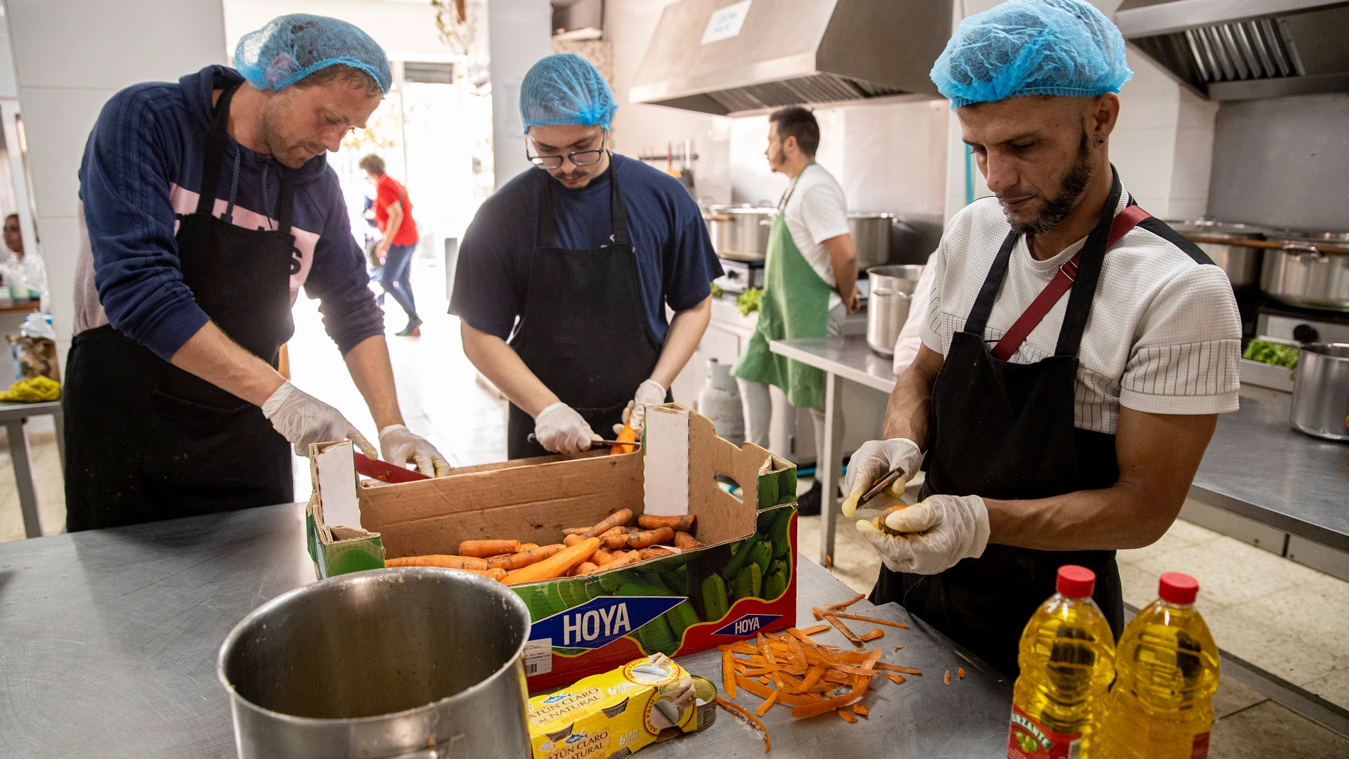 Unos voluntarios pelan zanahorias en la cocina de la ONG "Yo soy tú", ubicado en un barrio obrero de Málaga EFE/Jorge Zapata.