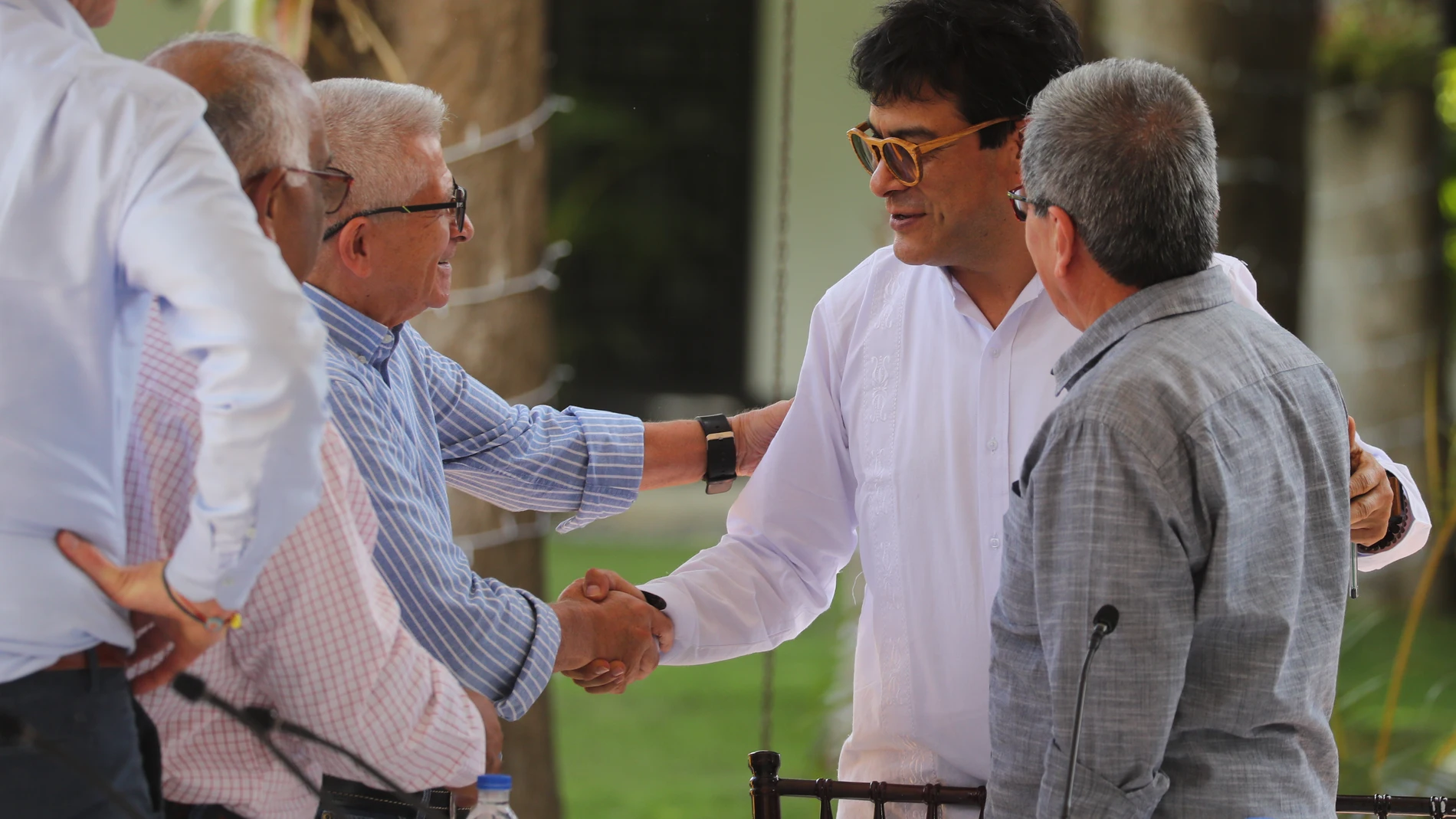 El portavoz del Gobierno colombiano Iván Danilo Rueda (c) conversa con los representantes del ELN Aureliano Carbonell (i) y Pablo Beltrán (d) durante una reunión en Caracas