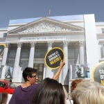 Un grupo de mujeres pertenecientes al Movimiento Feminista de Madrid sostienen pancartas durante una acción reivindicativa frente al Congreso de los Diputado