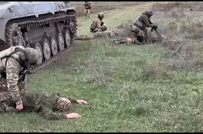 Soldados ucranianos detienen a soldados rusos que se acaban de rendir tras salir de un tanque en la región de Jersón