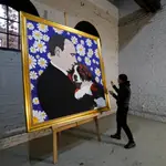 El artista ruso Alexey Sergienko posa junto a su obra &quot;Putin con su mascota&quot; dedicada al presidente de su país por su cumpleaños