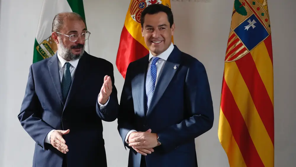 Los presidentes de la Junta de Andalucía, Juanma Moreno (d), y el del Gobierno de Aragón, Javier Lambán, conversan a su llegada al Palacio de San Telmo. EFE/José Manuel Vidal