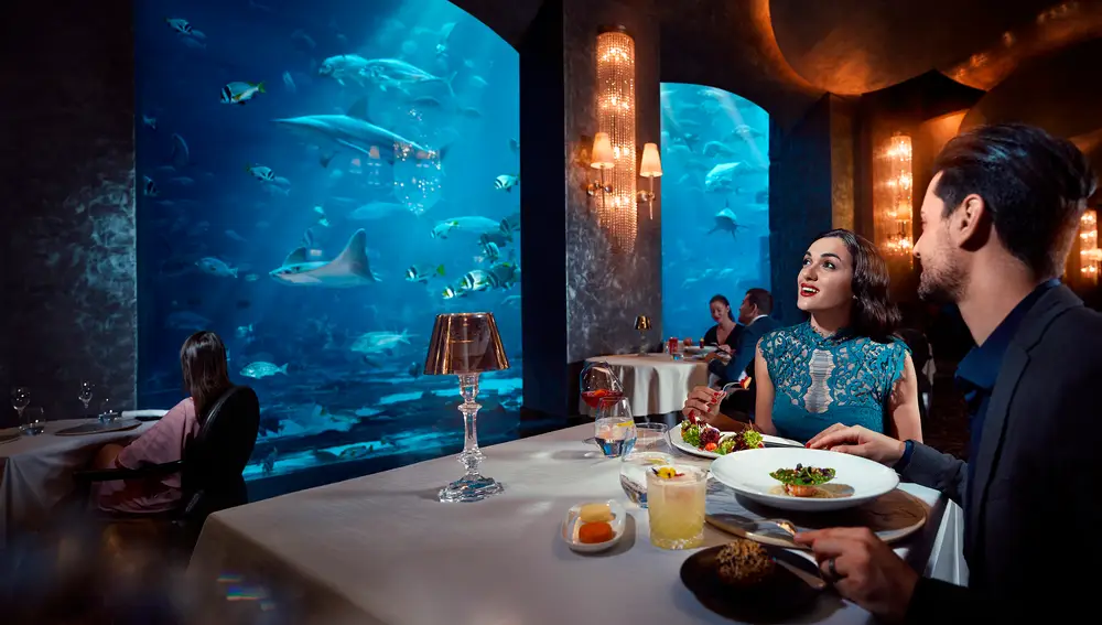 El restaurante Ossiano, ubicado en el mítico Hotel Atlantis, ofrece una experiencia única en la que se marida una carta de estrella Michelin con el placer de degustarla rodeado de fauna marina