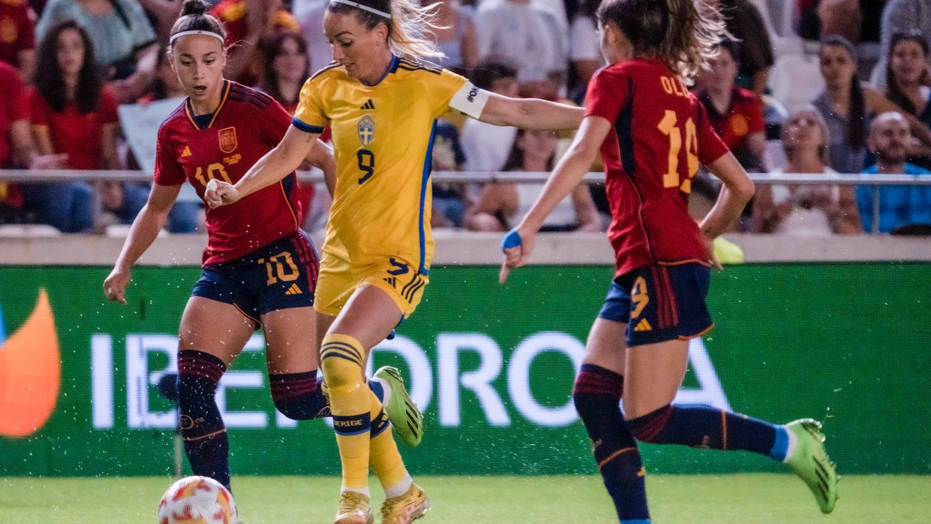 La delantera de la selección de Suecia, Kosovare Asllani conduce el balón ante las jugadoras de la selección española Athenea del Castillo y Olga Carmona