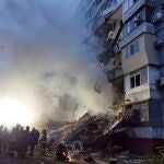 Bomberos tratan de buscar supervivientes en las ruinas de un edificio dañado por el impacto de la artillería rusa este domingo en Zaporiyia