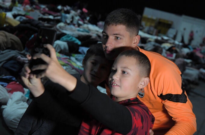 Dos niños ucranianos refugiados en Varsovia se hacen un selfie con Bondar, central del Shakhtar