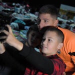 Dos niños ucranianos refugiados en Varsovia se hacen un selfie con Bondar, central del Shakhtar