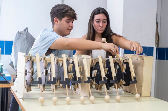 Los alumnos Aarón Reina y Cristina Fernández del IES Almunia de Jerez de la Frontera (Cádiz) junto a la máquina que han diseñado y construido, con materiales reciclados