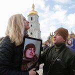 Natalia reacciona mientras sostiene un retrato de su hijo perdido en la exposición callejera "Regimiento Azov - Ángeles de Mariupol", dedicada a los defensores de la unidad "Azov" de la Guardia Nacional de Ucrania