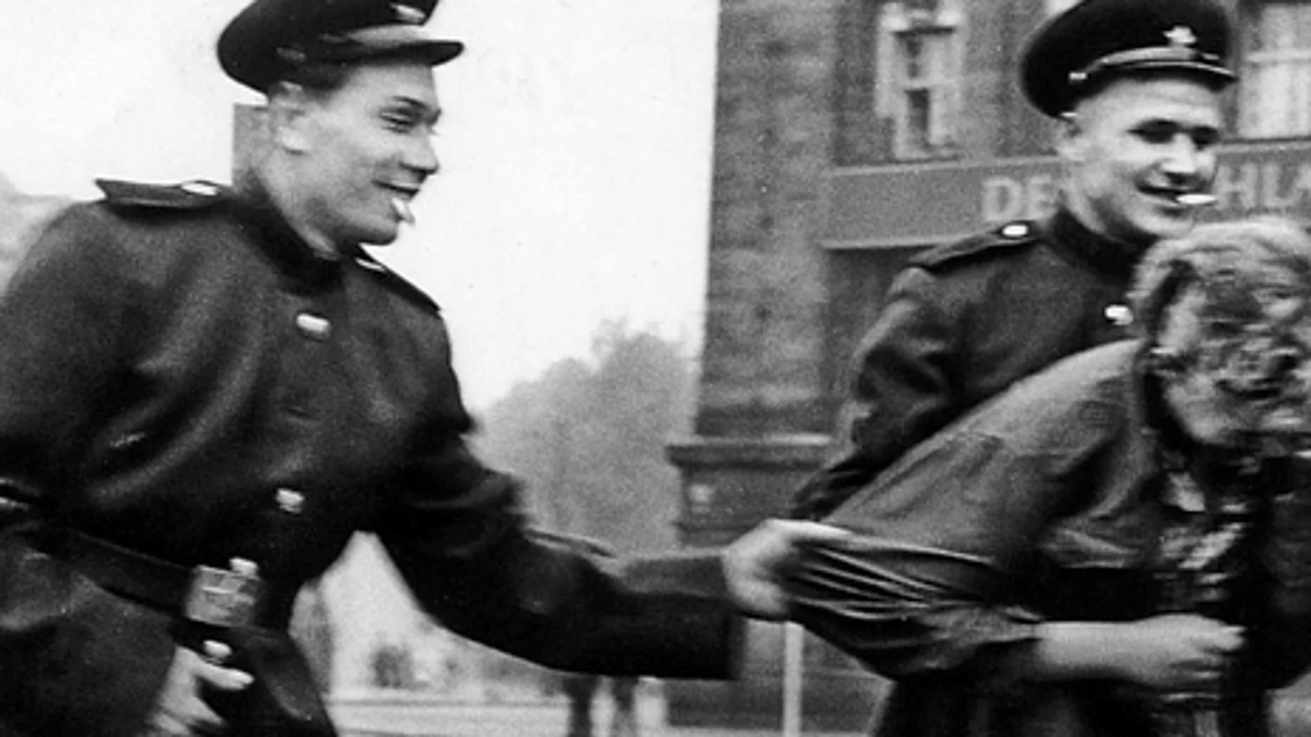 Dos soldados rusos acosan a una mujer alemana después de tomar Berlín