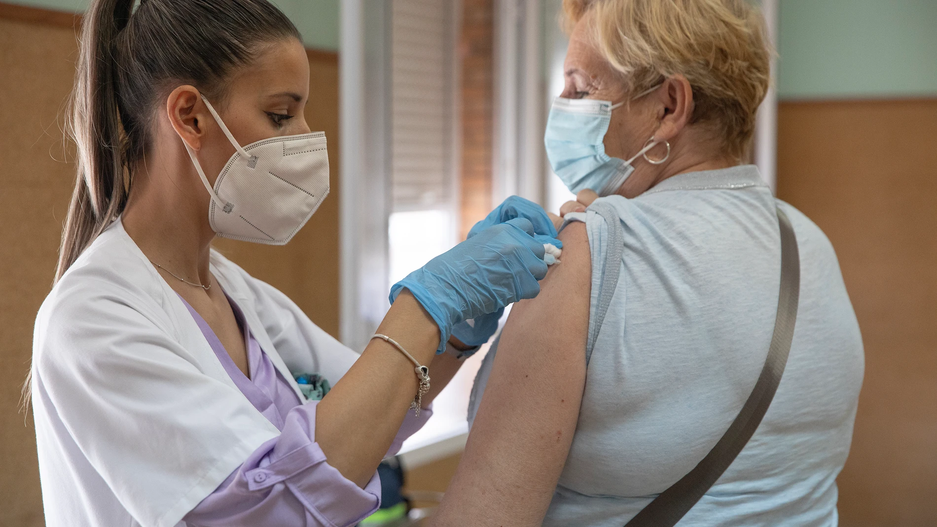 Una enfermera vacuna a una mujer contra la gripe y el Covid. María José López / Europa Press