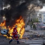 Un trabajador sanitario pasa junto a coche incendiado tras una explosión en Kiev