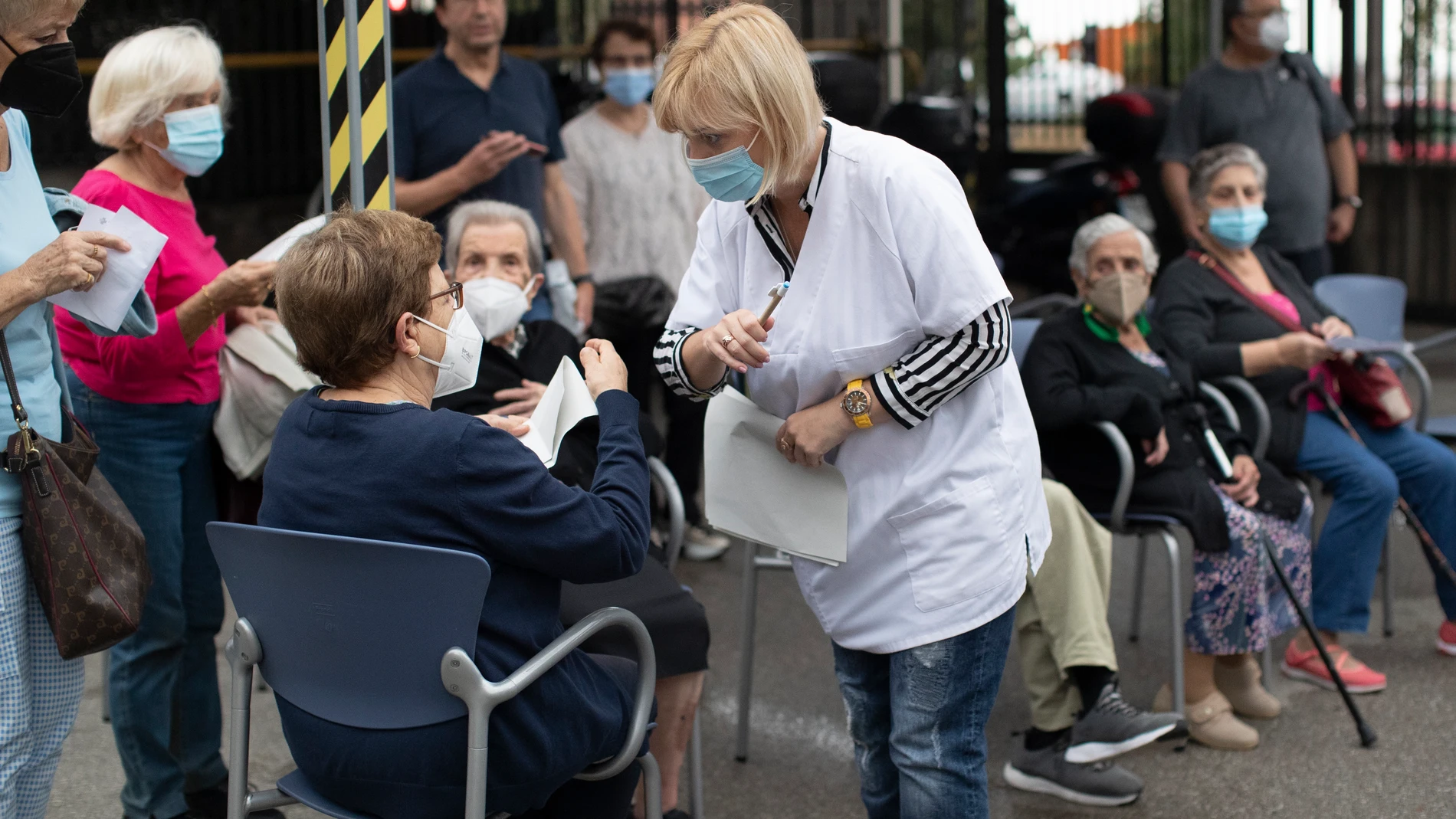Una profesional sanitaria atiende a personas que se disponen a vacunarse contra la covid en Barcelona
