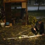 Un hombre corta trozos de leña en Kivsharivka, Ucrania. A medida que las temperaturas descienden por debajo del punto de congelación en el este de Ucrania, aquellos que no han huido de los intensos combates, los bombardeos regulares y los meses de ocupación rusa se encuentran en el umbral de un invierno brutal y se atrincheran para pasar los meses de frío
