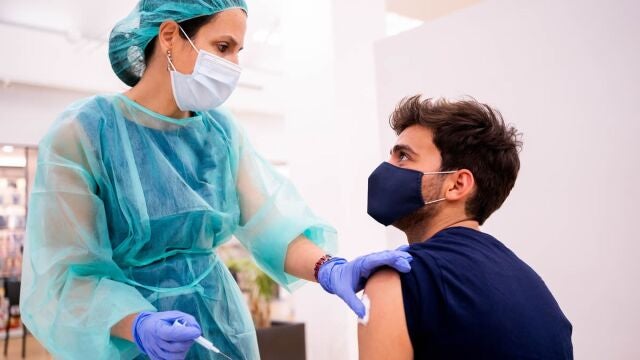 Una farmacéutica vacuna a un joven en una campaña de vacunación