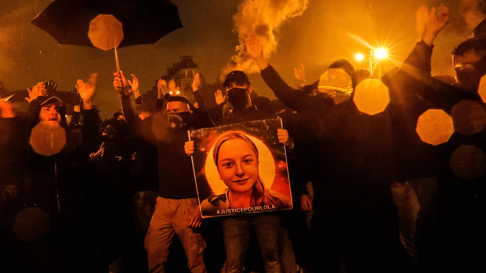 Un hombre sostiene una ilustración con el retrato de Lola durante una manifestación de extrema derecha al final del homenaje a esta joven asesinada en un barrio del norte de la capital francesa
