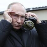 El presidente ruso Vladimir Putin se coloca unas gafas protectoras mientras visita un centro de formación militar del Distrito Militar Occidental para reservistas movilizados en la región de Riazán