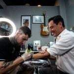 Juanma Moreno se tatúa en el estudio Barbiere. PP