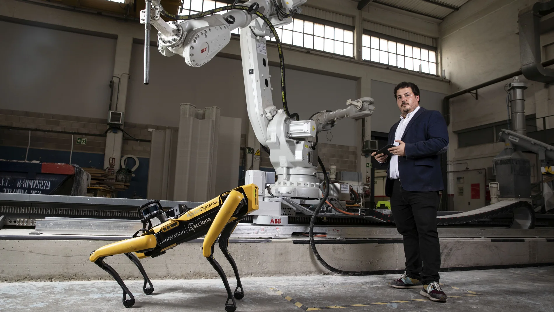 Carlos Crespo, Automation & Robotics Manager, con el perro robot y el brazo robótico que Acciona tiene en su centro de innovación