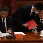 El presidente chino Xi Jinping, a la izquierda, observa cómo el ex presidente chino Hu Jintao es ayudado a abandonar la sala durante la ceremonia de clausura del 20º Congreso Nacional del gobernante Partido Comunista de China