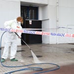 Una mujer limpia la zona del suceso en las inmediaciones de la discoteca ‘Caña Brava’, en Fuenlabrada, Madrid