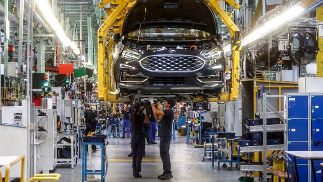 Dos trabajadores con un vehículo de la fábrica de Ford en Almussafes,