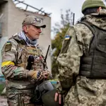 Soldados ucranianos se toman un descanso mientras buscan explosivos en una zona recapturada en el norte de Jersón