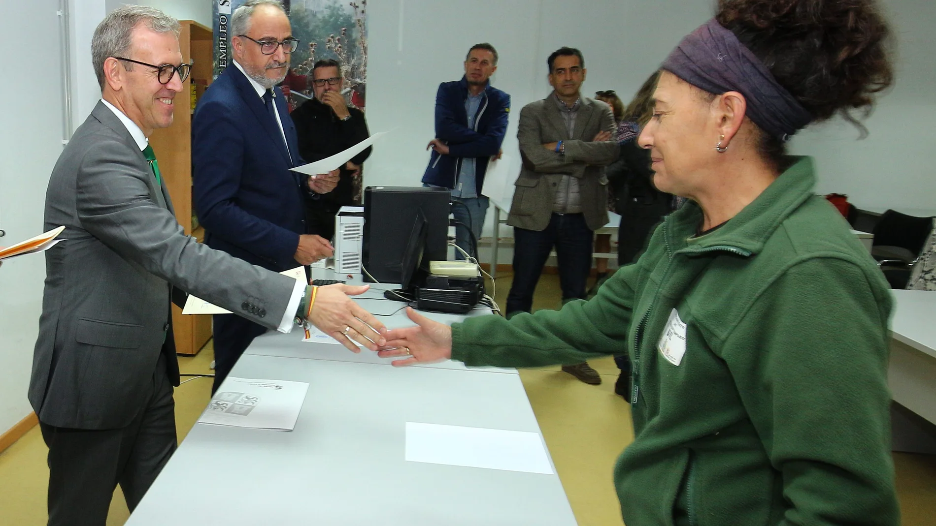 El consejero de Industria, Comercio y Empleo, Mariano Veganzones, entrega uno de los diplomas a una alumna que se ha formado en uno de estos talleres duales de empleo en Ponferrada