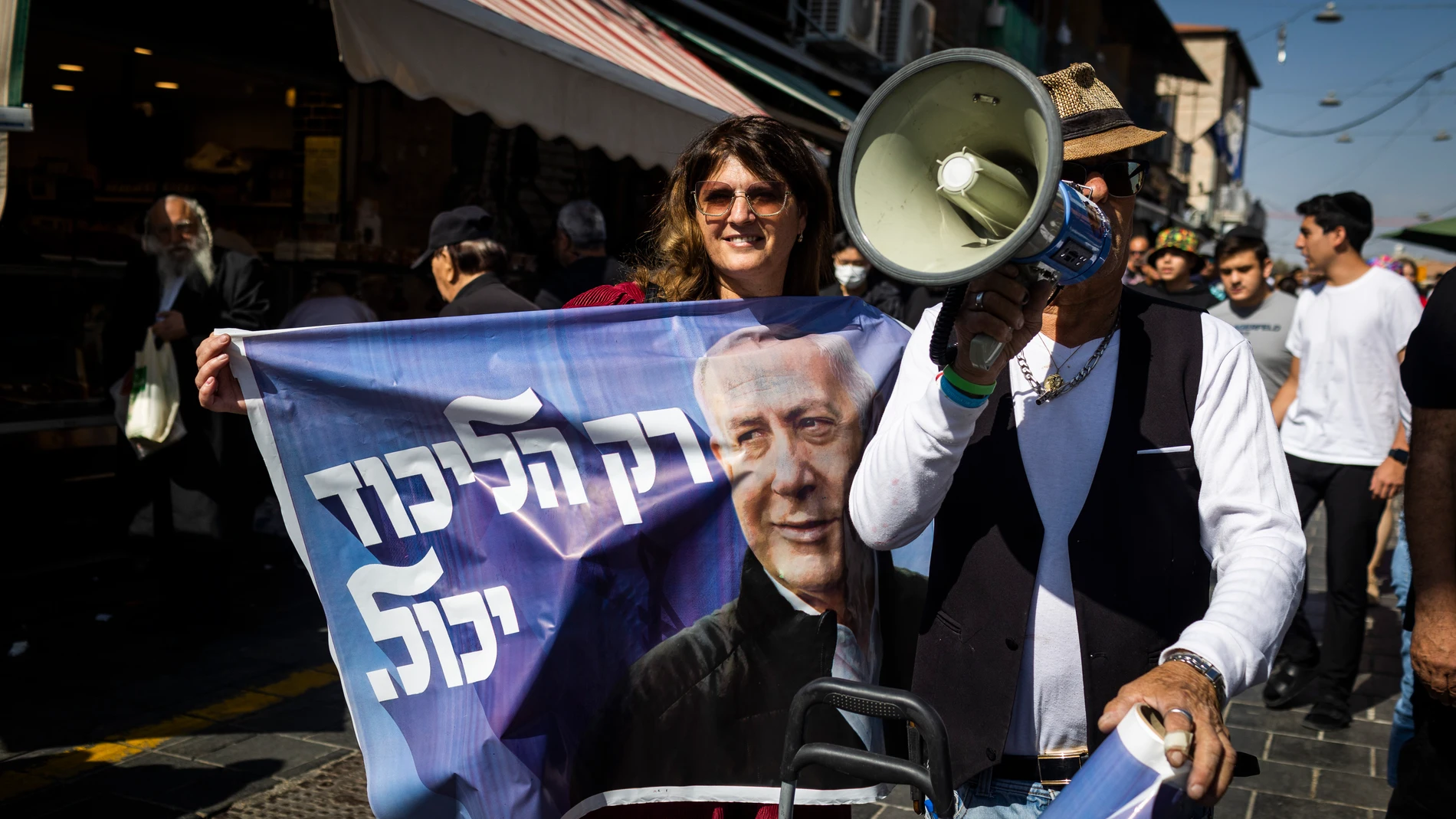 Simpatizantes sostienen pancartas del líder del partido Likud y ex primer ministro israelí Benjamín Netanyahu, durante una campaña en el mercado de Jerusalén
