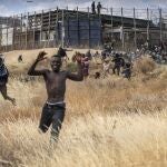 Migrants run on Spanish soil after crossing the fences separating the Spanish enclave of Melilla from Morocco in Melilla, Spain