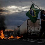 Una mujer sostiene una bandera de Brasil durante bloqueo de camioneros cerca a Volta Redonda. Los camioneros de Brasil bloquearon al menos 70 puntos en carreteras de todo el país en protesta por la derrota en las elecciones del presidente Jair Bolsonaro, s
